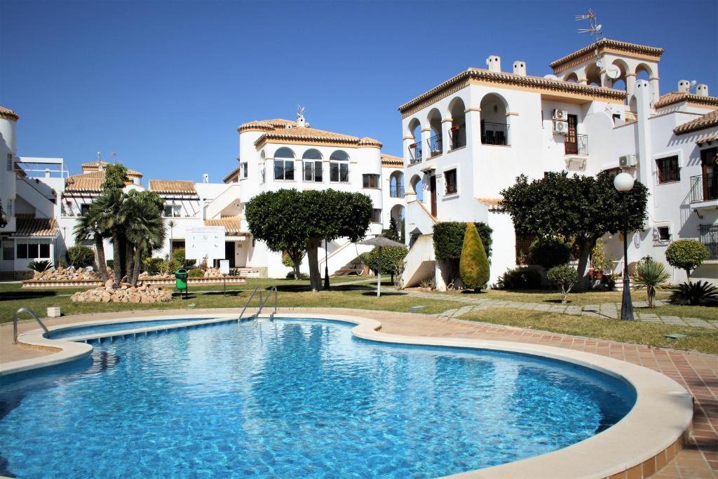 einem großen Pool vor einem Gebäude in der Unterkunft Playa Flamenca Casa 88 in Playa Flamenca