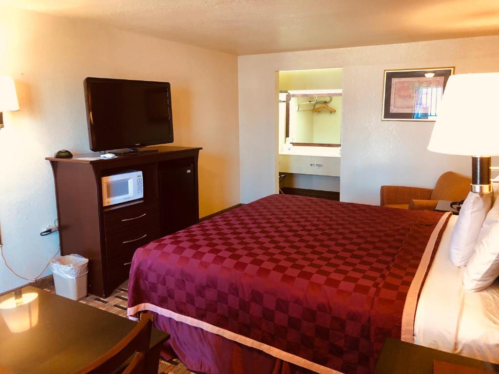 a hotel room with a bed and a flat screen tv at Americas Best Value Inn and Suites Hope in Hope