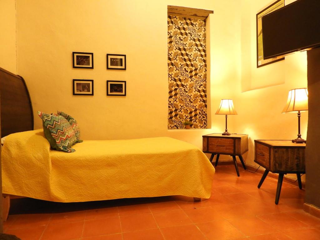 a hotel room with a bed and a flat screen tv at El Rinc&oacute;n de Cervantes Secret House by Lunian in Guanajuato