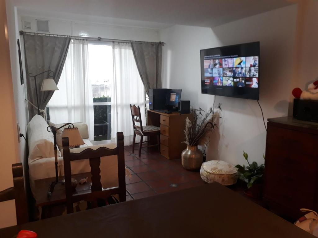a living room with a television and a dining room at La Nenena in Rosario