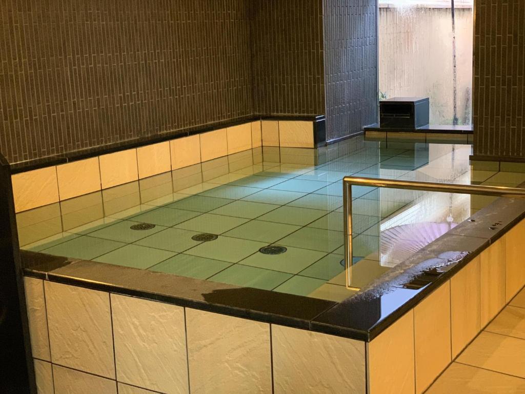 
a bath tub sitting inside of a bathroom next to a walk in shower at Niigata Daiichi Hotel in Niigata
