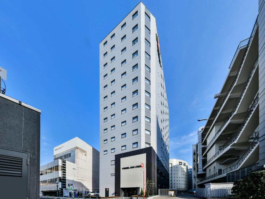 um edifício branco alto numa cidade em Vessel Inn Chiba Ekimae em Chiba