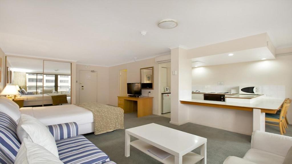 a hotel room with a bed and a living room at Studio with balcony at College St in Sydney