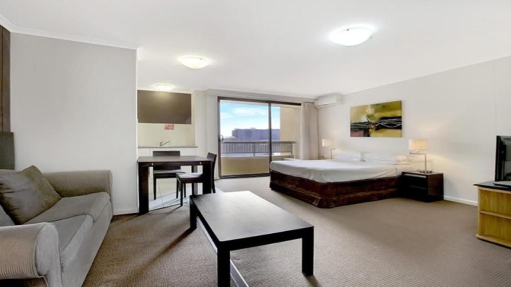 a hotel room with a bed and a desk at In the City Studio at College St in Sydney