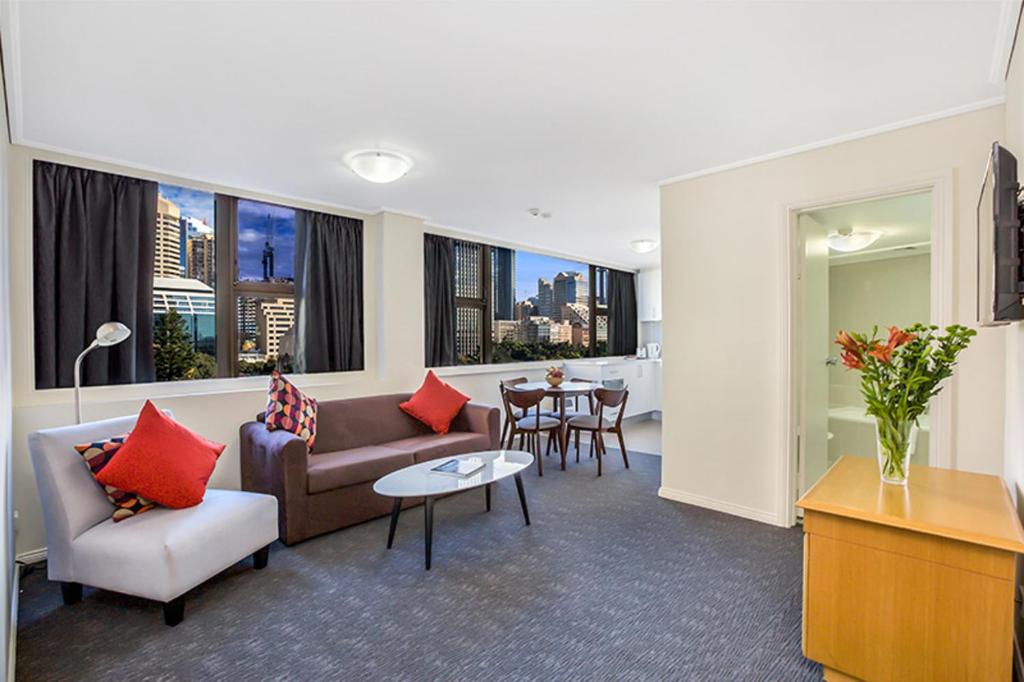 een woonkamer met een bank en een tafel bij Apartment at College St in Sydney
