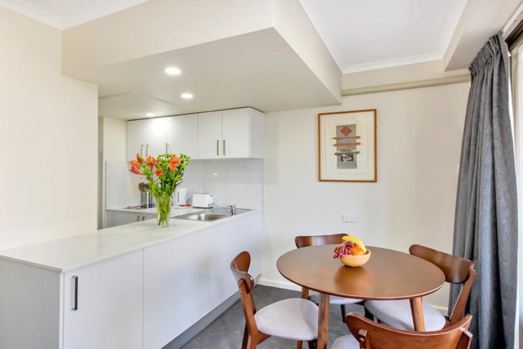 a kitchen with a table and chairs in a kitchen at City apartment at College St in Sydney