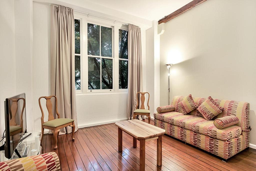 a living room with a couch and two chairs at Apartment Harborside Comfort in Sydney