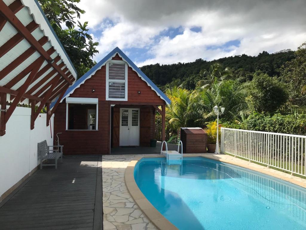 a house with a swimming pool next to a building at Iguane Rouge in Petit-Bourg