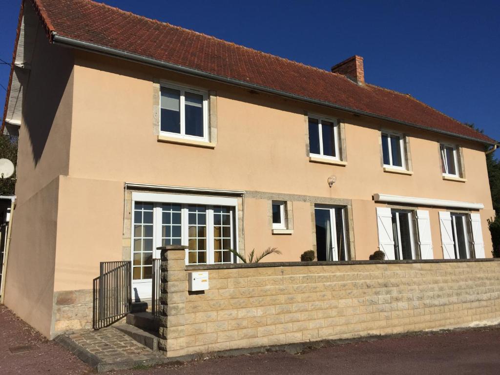 a house with a brick fence in front of it at Meublé 3 étoiles, proche Plages débarquement dans les Marais du Cotentin à Carentan in Carentan