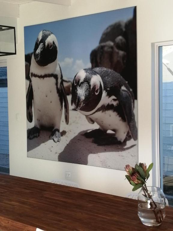 two penguins are standing next to each other at Peach on Beach Boutique Guesthouse in Bloubergstrand
