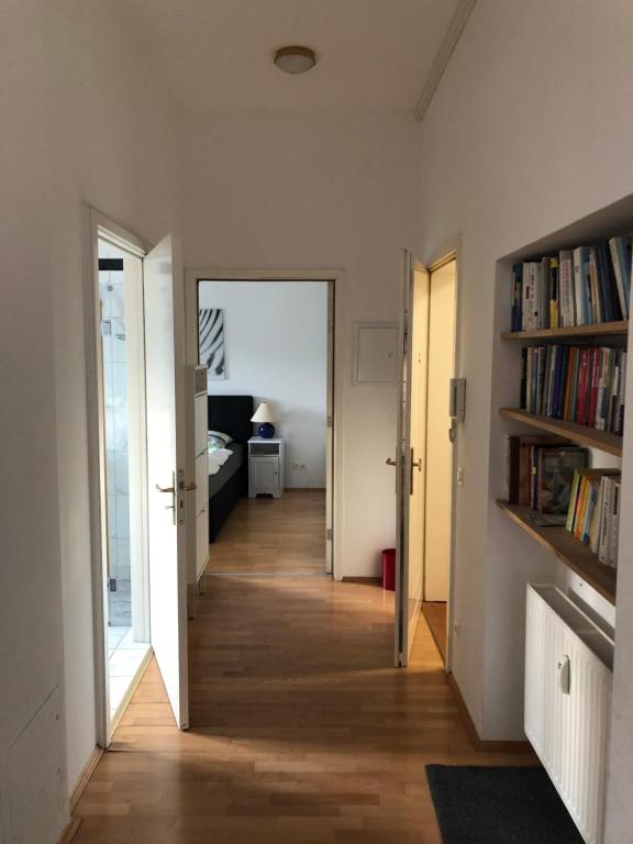 um corredor com um corredor que leva a um quarto com livros em Ferienwohnung mitten in Wiesbaden em Wiesbaden