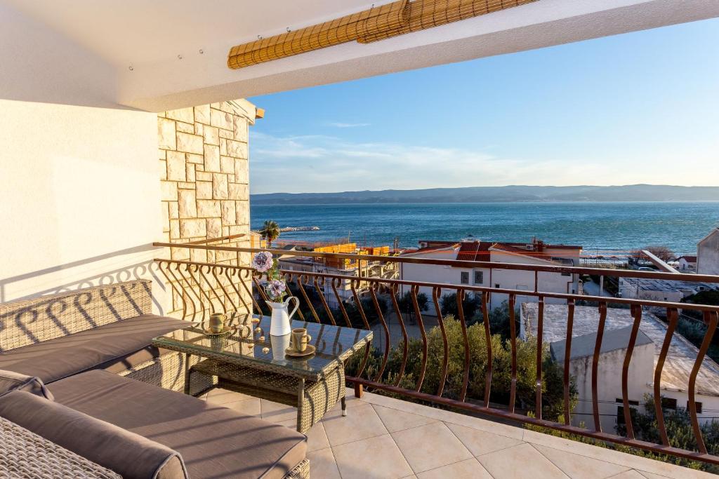 a balcony with a table and a view of the ocean at Luxury suites Juričević in Duće