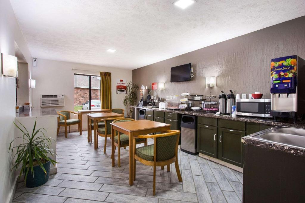 eine Küche mit einem Tisch, Stühlen und einer Theke in der Unterkunft Red Lion Inn & Suites Olathe Kansas City in Olathe