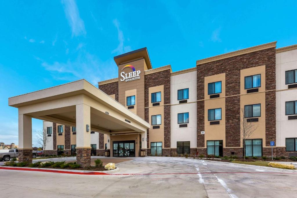 ein Hotel mit einem Schild auf der Vorderseite in der Unterkunft Sleep Inn & Suites Fort Worth - Fossil Creek in Fort Worth