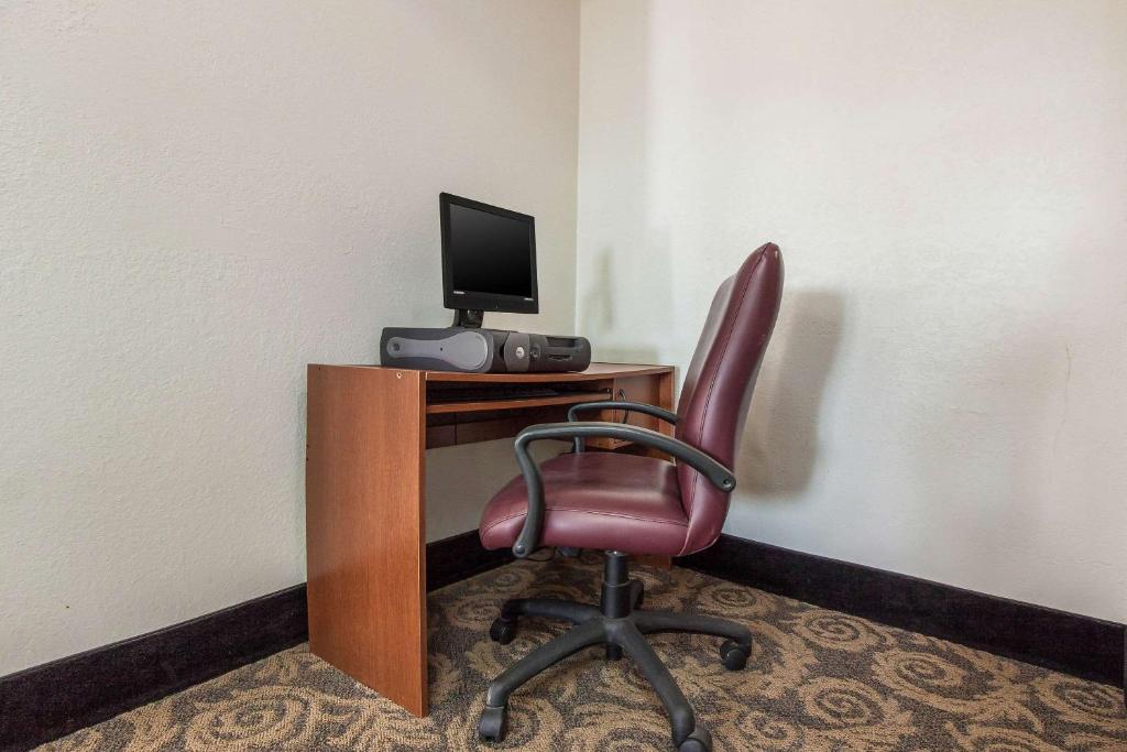 a red chair sitting in front of a desk with a computer at Econo Lodge in Lexington