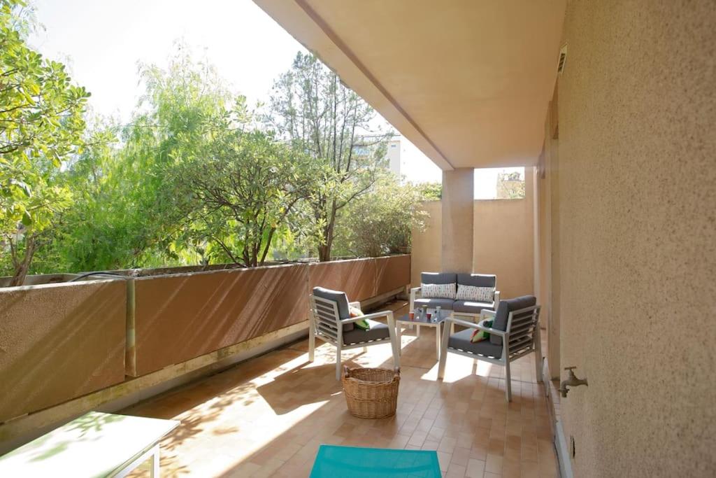 a patio with chairs and a table on a balcony at Dans un écrin de verdure in Hyères