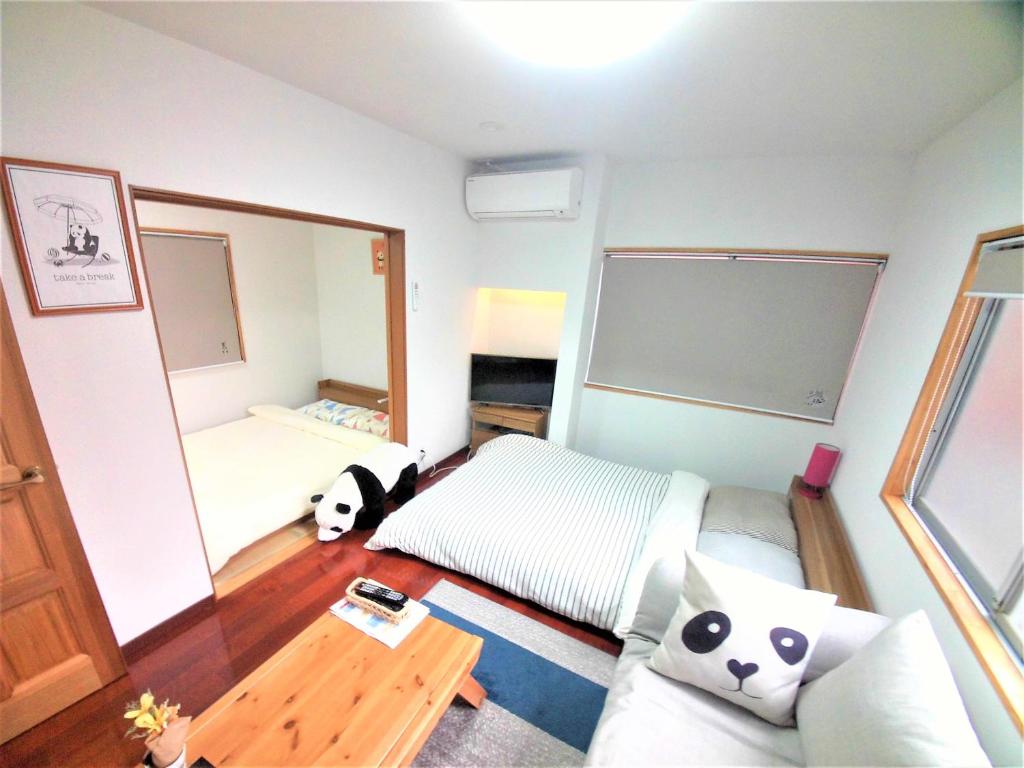 a bedroom with a bed and a large mirror at Panda Stay Okayama in Okayama
