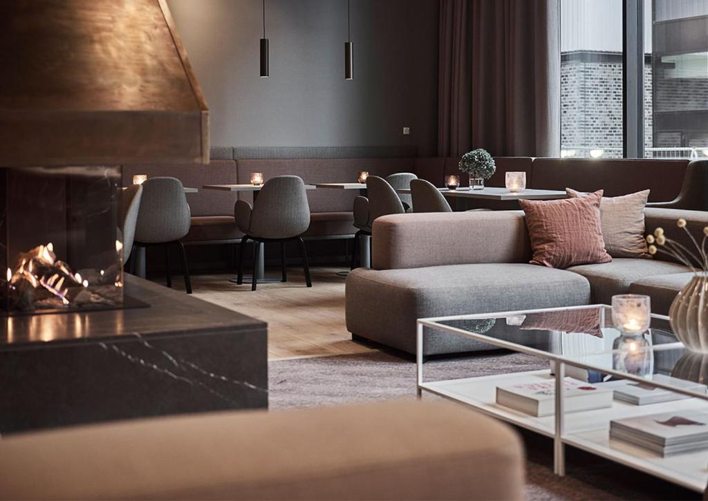a living room with a couch and tables and chairs at Hotel Odeon in Odense