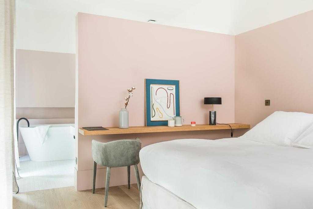 a bedroom with a bed and a desk with a chair at Maison Aribert in Saint-Martin-dʼUriage