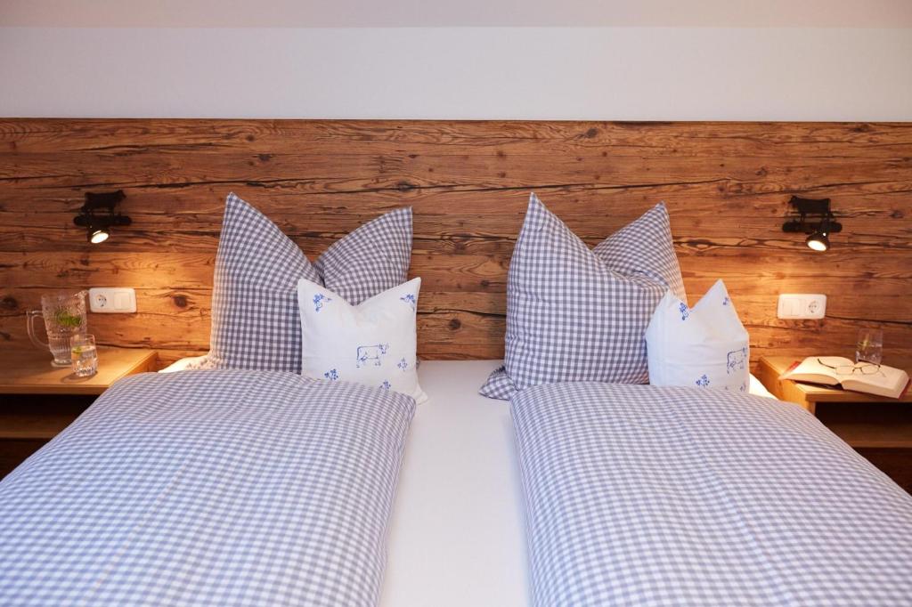 uma cama com almofadas azuis e brancas em Ferienhof Ücker em Waltenhofen
