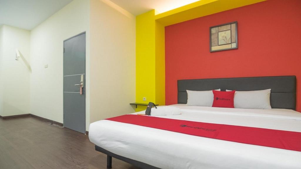 雅加達的住宿－RedDoorz near ITC Mangga Dua，一间卧室设有一张大床和色彩缤纷的墙壁