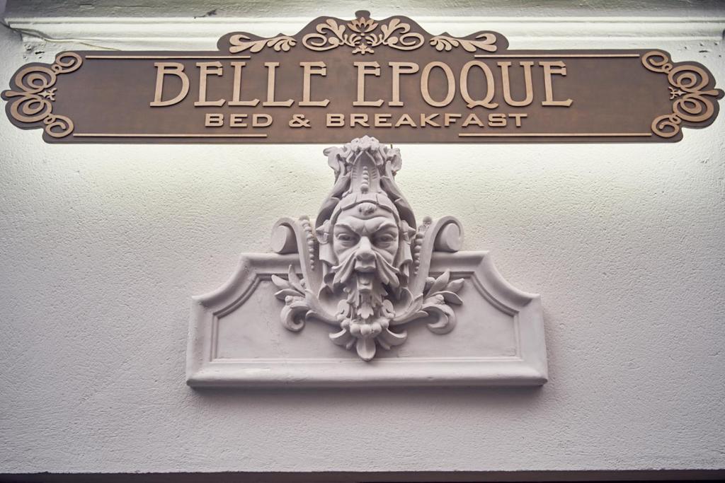 a sign for a bed and breakfast on a wall at Belle Epoque in Poznań