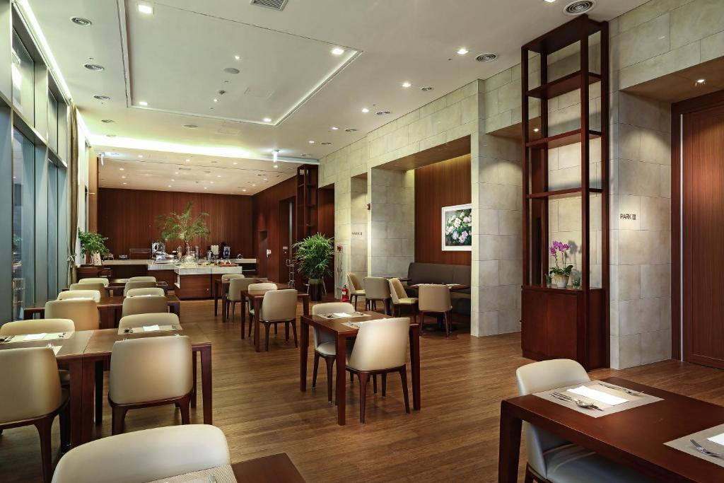 a restaurant with tables and chairs in a room at Parksunshine Jeju in Seogwipo