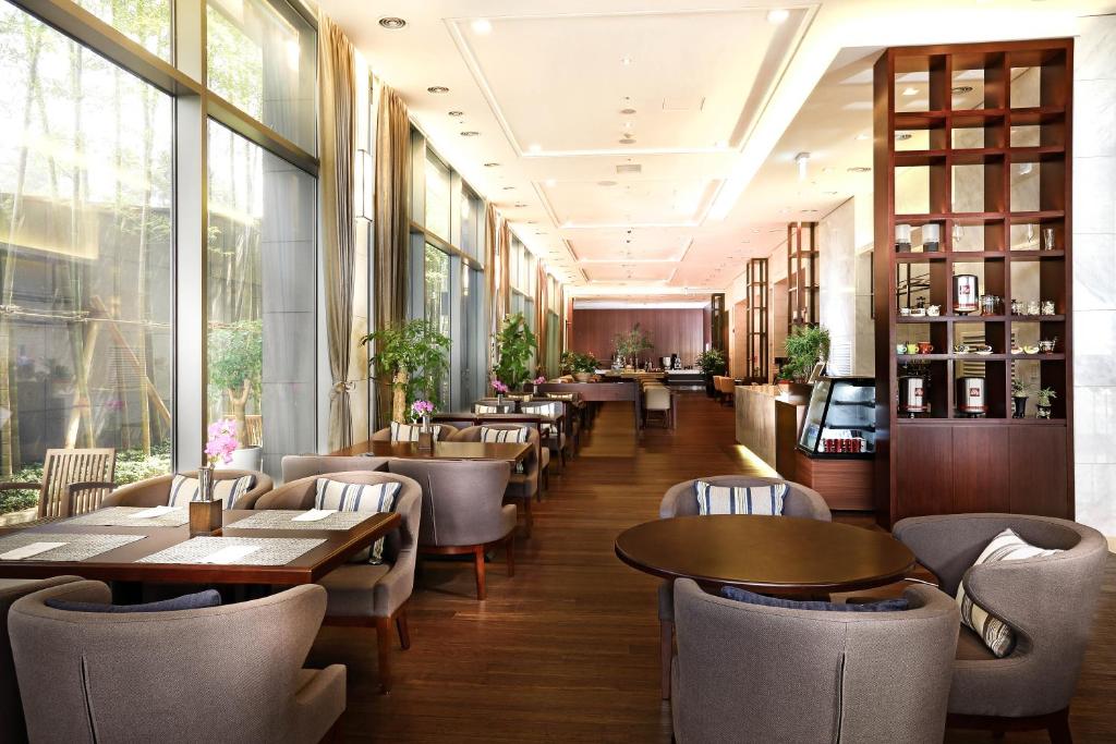 a restaurant with tables and chairs and windows at Parksunshine Jeju in Seogwipo