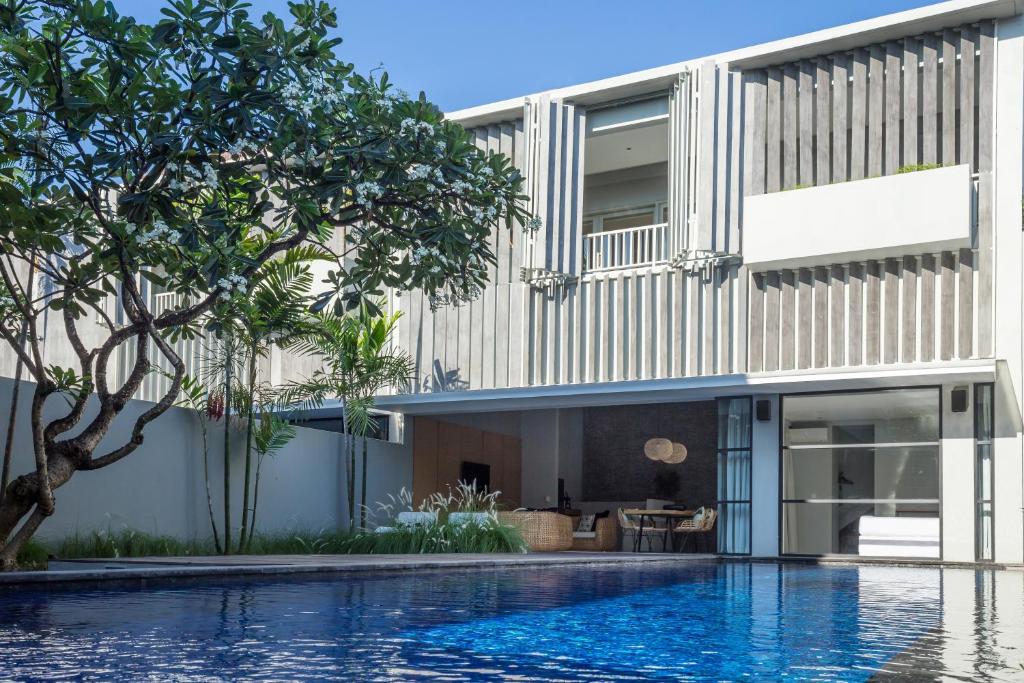 a house with a swimming pool in front of it at Origin Seminyak in Seminyak