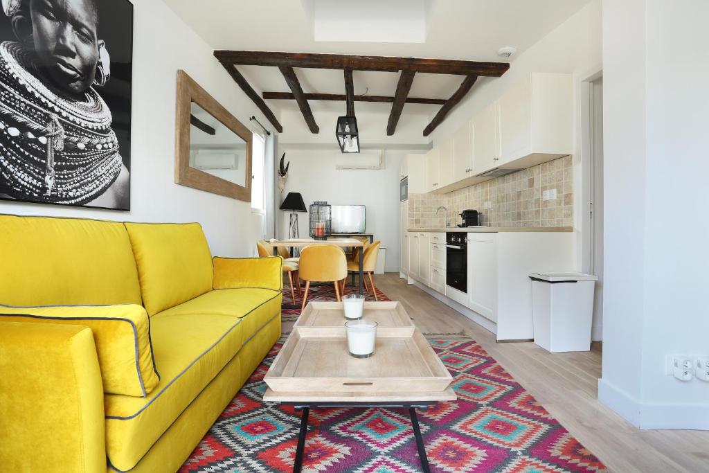 - un salon avec un canapé jaune et une table dans l'établissement Résidence Grands Boulevards by Studio prestige, à Paris