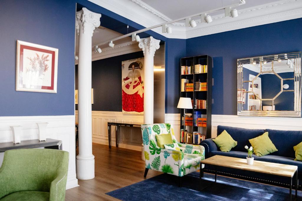 una sala de estar con paredes azules y columnas blancas en Petit Palace Lealtad Plaza, en Madrid