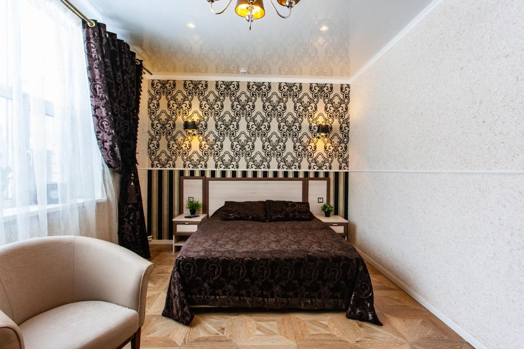 1 dormitorio con 1 cama y 1 silla en Guest house Vasco Da Gama, en Tver