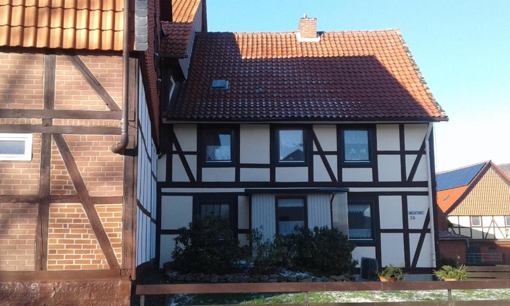 une maison noire et blanche avec un toit brun dans l'établissement Ferienwohnung ROSA, à Hahausen