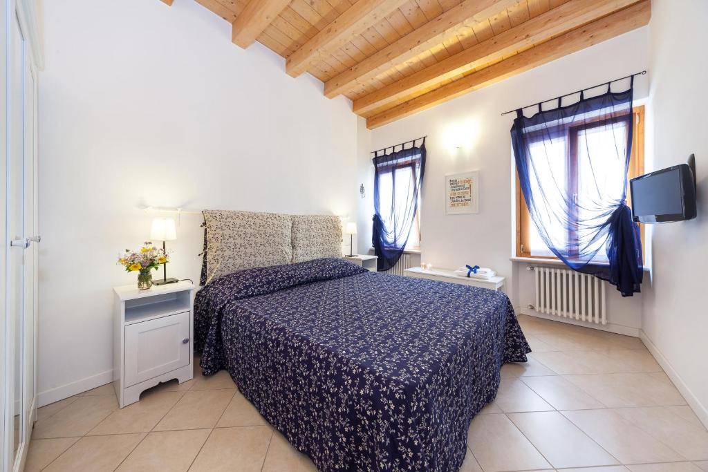 1 Schlafzimmer mit einem Bett mit blauer Decke und 2 Fenstern in der Unterkunft B&B King in Verona