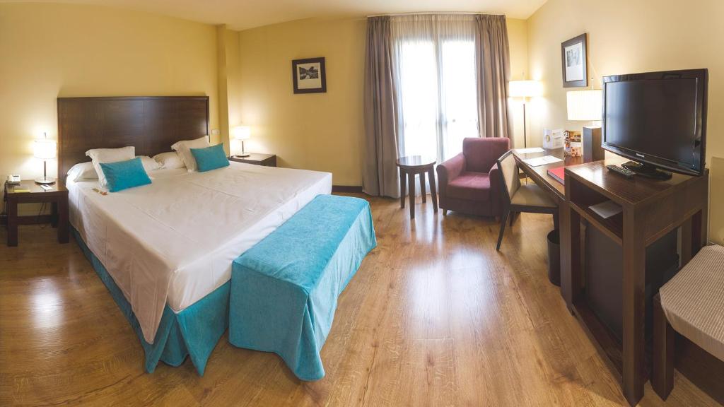Postel nebo postele na pokoji v ubytování Gran Hotel Ciudad de Barbastro