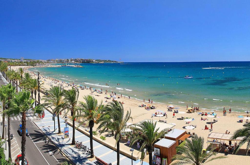a beach with a lot of people and the ocean at Apartamento Calipso in Salou