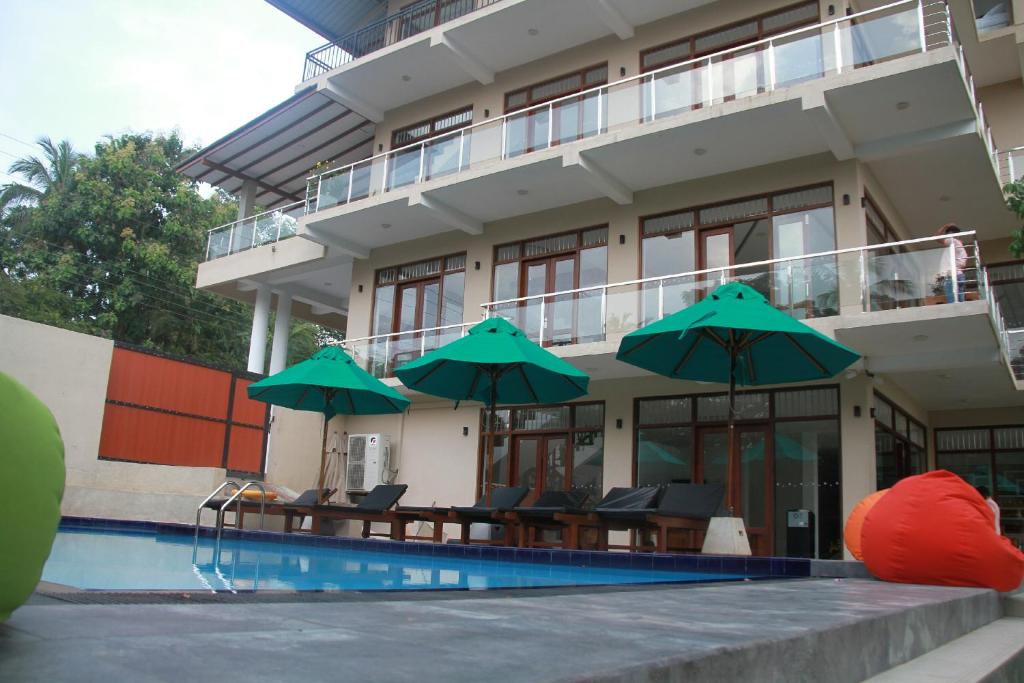 un hotel con una piscina con sombrillas en Sanu Lagoon Resort & Spa, en Tangalle