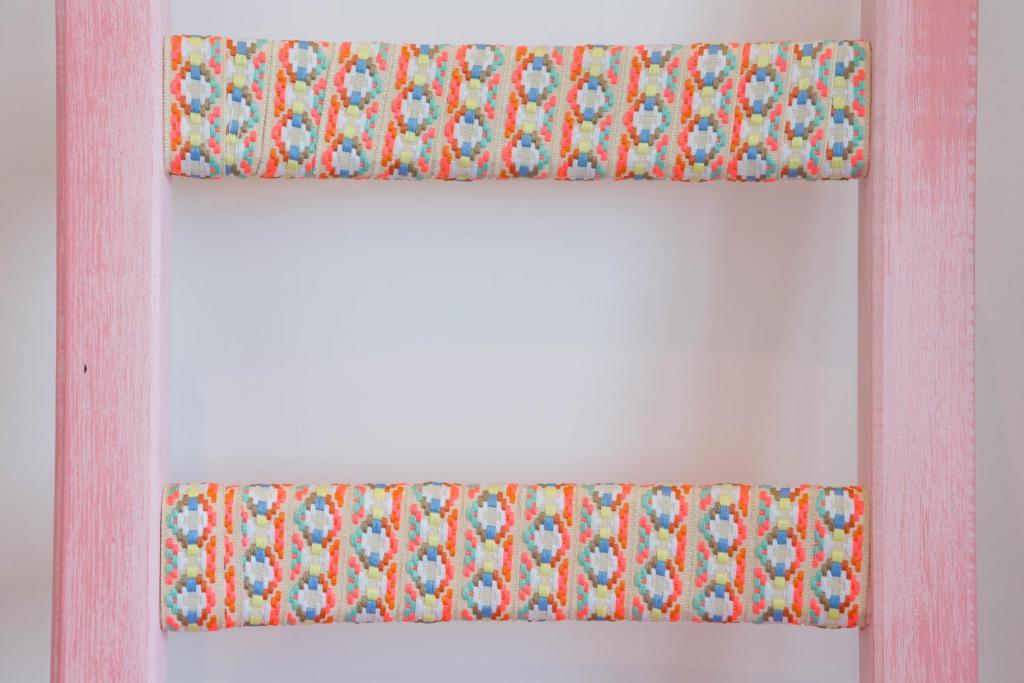 an orange and blue window curtain on a white wall at Cocor Suites & Design in Naples
