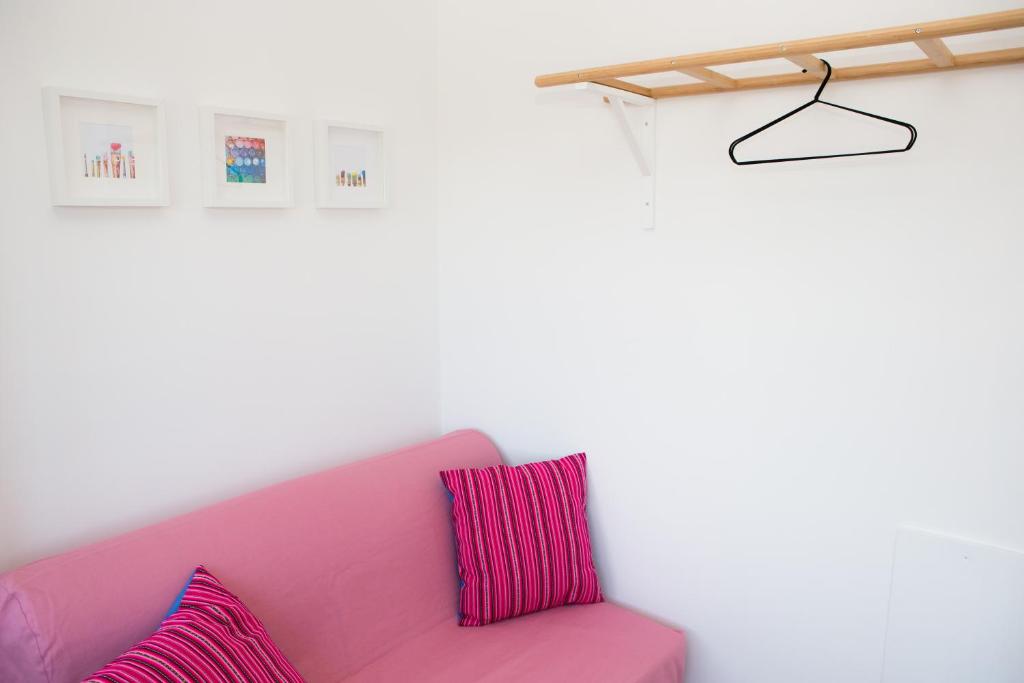 a pink couch with two pillows in a room at Cocor Suites & Design in Naples