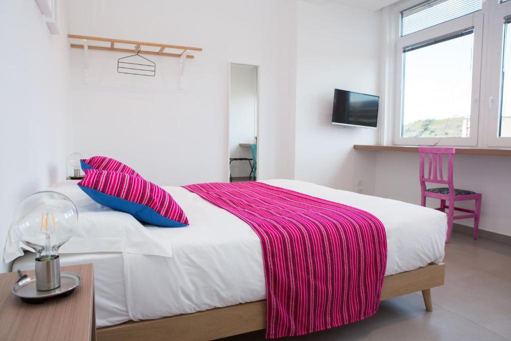 a bedroom with a bed with a pink blanket on it at Cocor Suites & Design in Naples