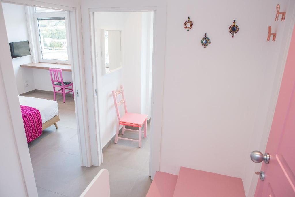 a room with pink chairs and a bed and a table at Cocor Suites & Design in Naples