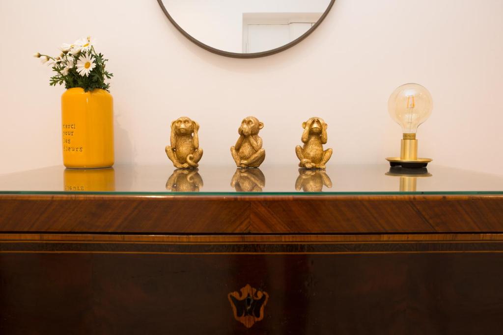 a table with three gold figurines on top of it at Cocor Suites & Design in Naples