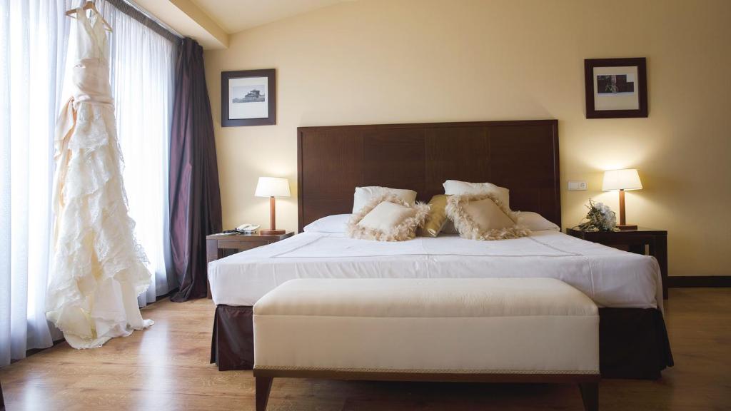 Postel nebo postele na pokoji v ubytování Gran Hotel Ciudad de Barbastro
