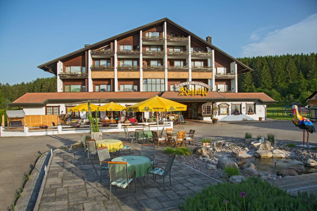 a large building with tables and chairs in front of it at Hostel am Schönenberg in Lenzkirch