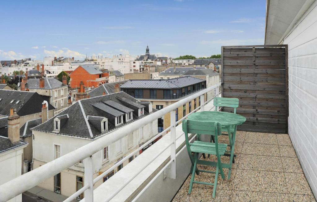 a balcony with two chairs and a view of a city at Séjours & Affaires Tours Léonard De Vinci in Tours