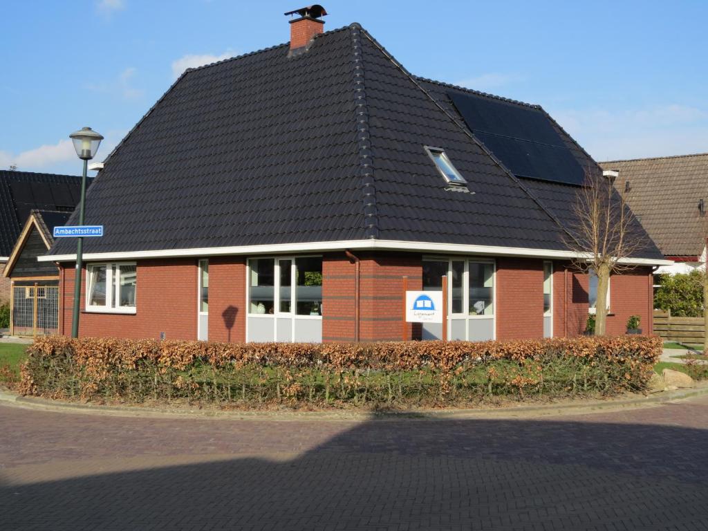 a red brick building with a black roof at Logement Gieten in Gieten