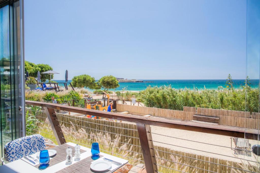 a balcony with a view of the beach and the ocean at Martinhal Sagres Beach Family Resort Hotel in Sagres