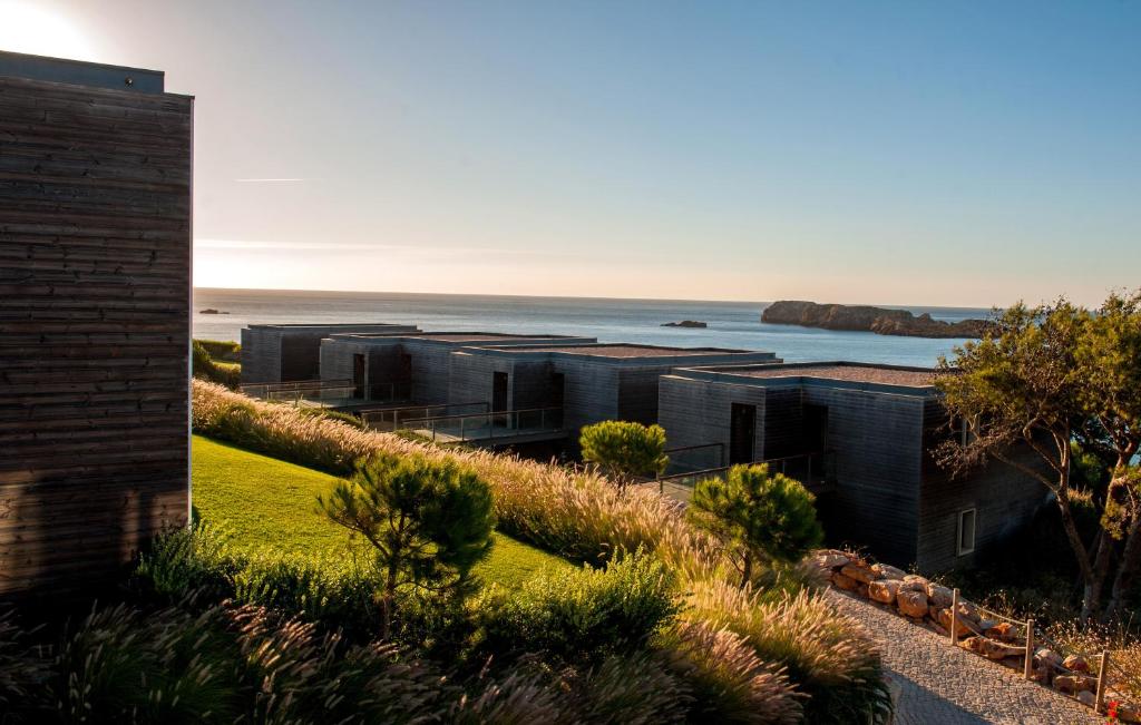 an exterior view of a building with the ocean in the background at Martinhal Sagres Beach Family Resort Hotel in Sagres