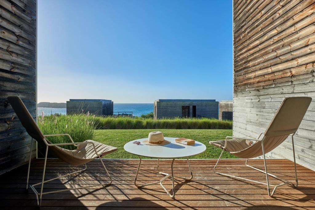 a patio with two chairs and a table with a hat on it at Martinhal Sagres Beach Family Resort Hotel in Sagres