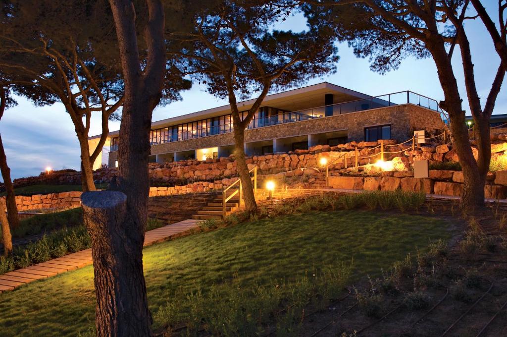 a building with lights in front of a yard at Martinhal Sagres Beach Family Resort Hotel in Sagres